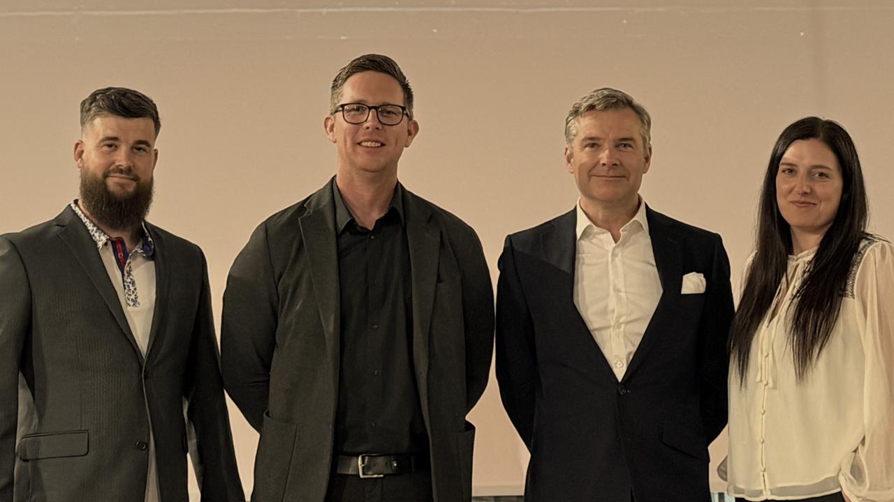 The Ops Con team with Sir Nick Borton in front of the partner network wall